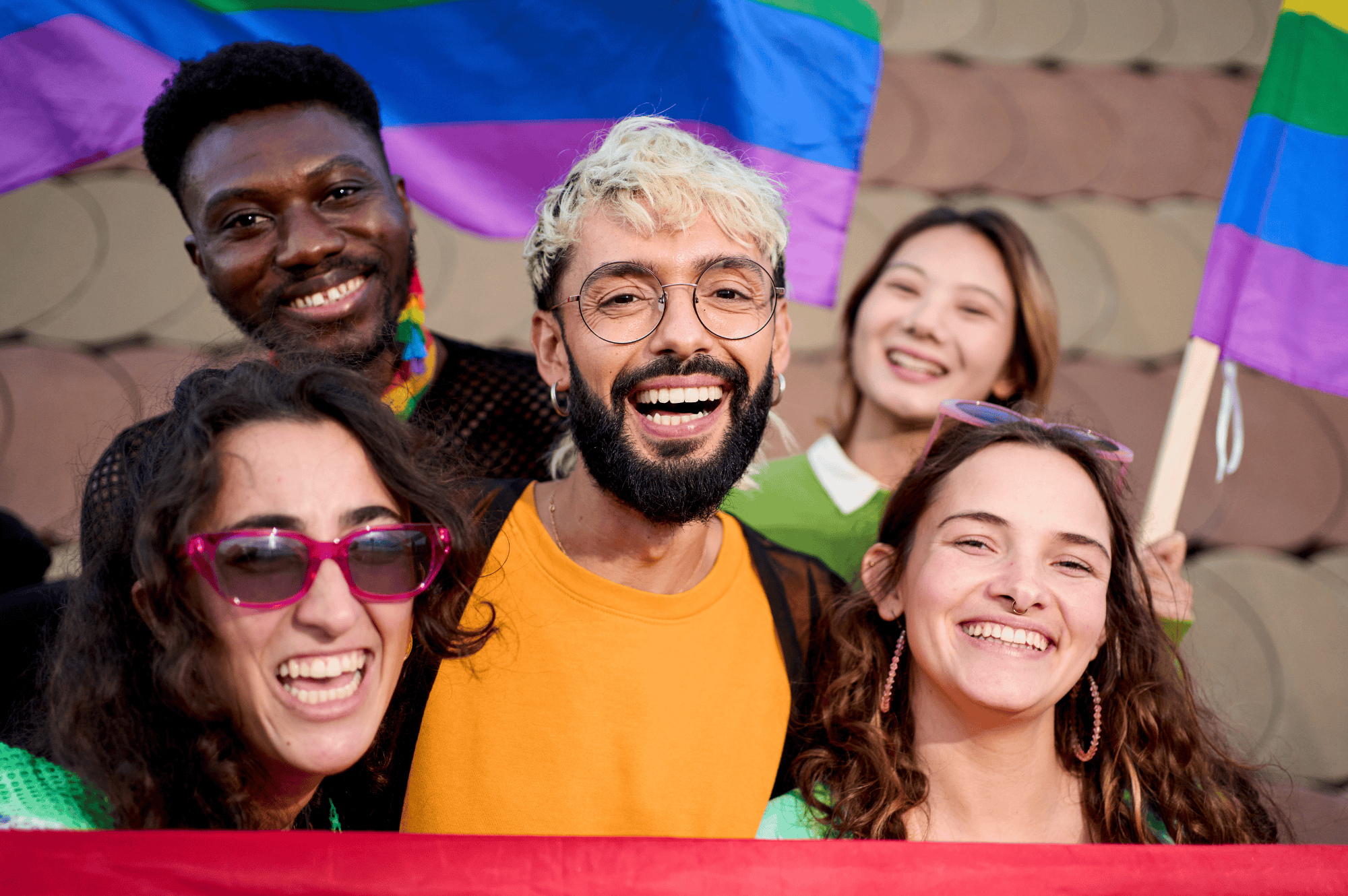 A group of friends celebrating pride. A pride flag can be seen in background.