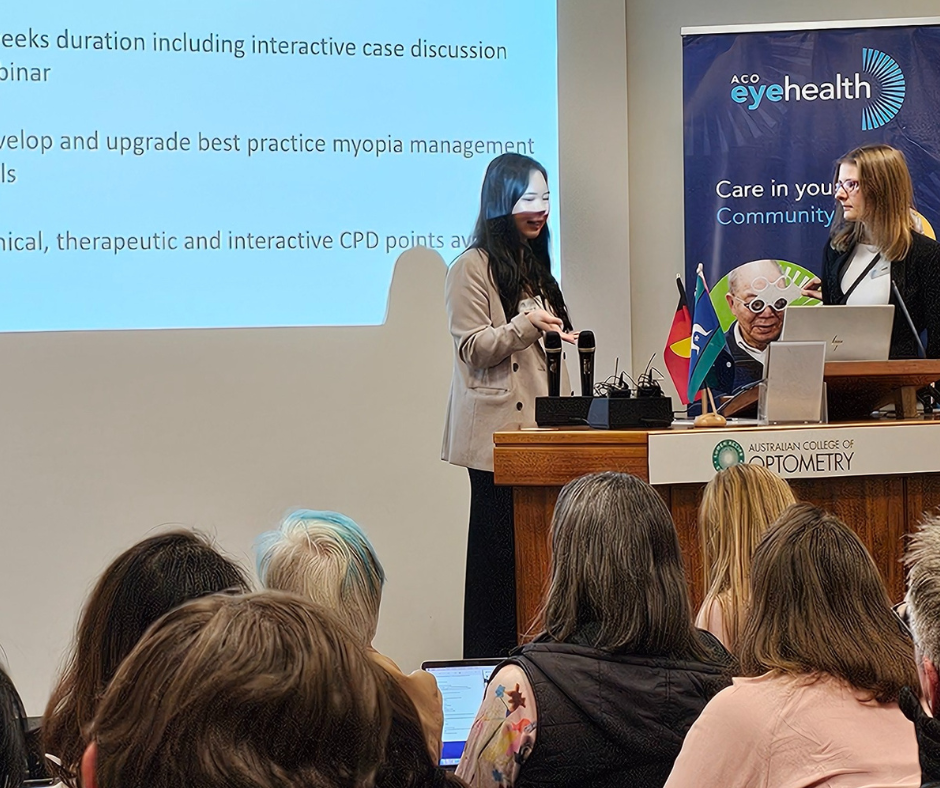 Two women at the podium on stage taking questions from audience members.
