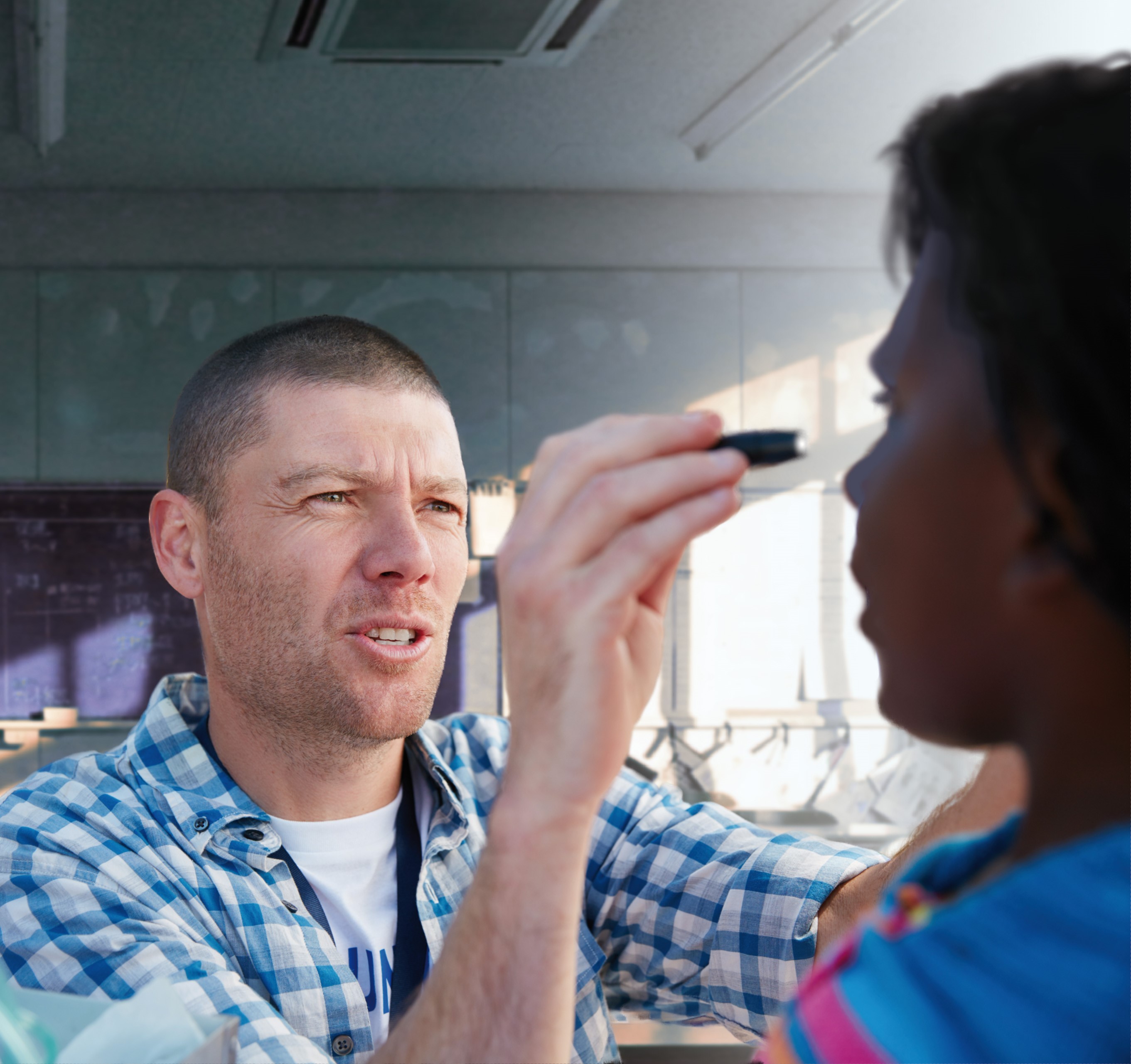 Man conducts eye test on Aboriginal woman. 