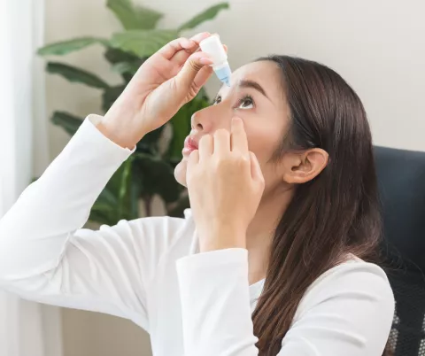 Woman putting eye drops in eyes