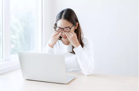 Woman experiencing dry eye while using computer